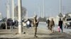 Afghan security personnel stand guard at the site of explosions in front of the Kabul Military Training Center in Kabul on November 18.