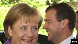 Russian President Dmitry Medvedev (right) welcomes German Chancellor Angela Merkel during their informal meeting in Sochi.