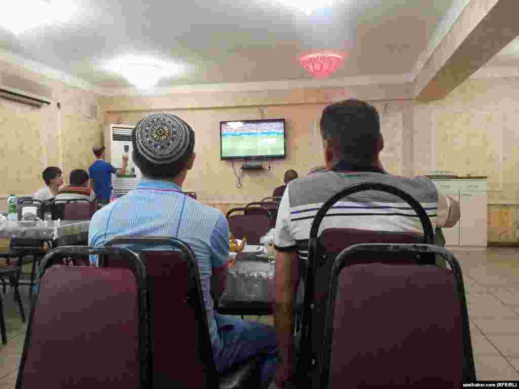 Garbanyşhanalaryň birinde futbola tomaşa edip oturan adamlar 