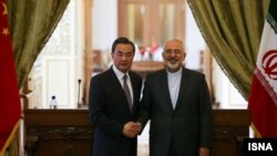 China's Wang Yi is welcomed by Iran's Mohammad Javad Zarif in Tehran on February 15.