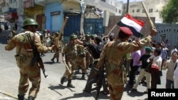 Йемен -- Аскерлер Салехтин колдоочулары менен кагылыша кеткен демонстранттарды таратууда. Таиз, 22-апрель.