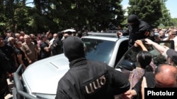 Armenia - Masked security officers are confronted by angry followers of the Armenian Apostolic Church in Echmiadzin, June 27, 2025.