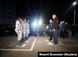 Dmitry Rogozin greets ISS crew members Aleksei Ovchinin of Russia and Nick Hague and Christina Koch of the United States shortly before their departure from the Baikonur Cosmodrome in Kazakhstan in March 2019.