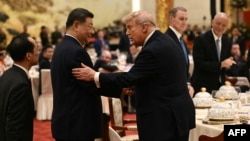 Chinese leader Xi Jinping and US President Donald Trump shake hands as they attend a state banquet at the Great Hall of the People in Beijing on May 14.