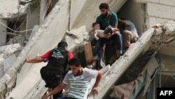 Syrian men remove a baby from the rubble of a destroyed building following a reported air strike in the Al-Qatarji neighborhood of the northern city of Aleppo on September 21.