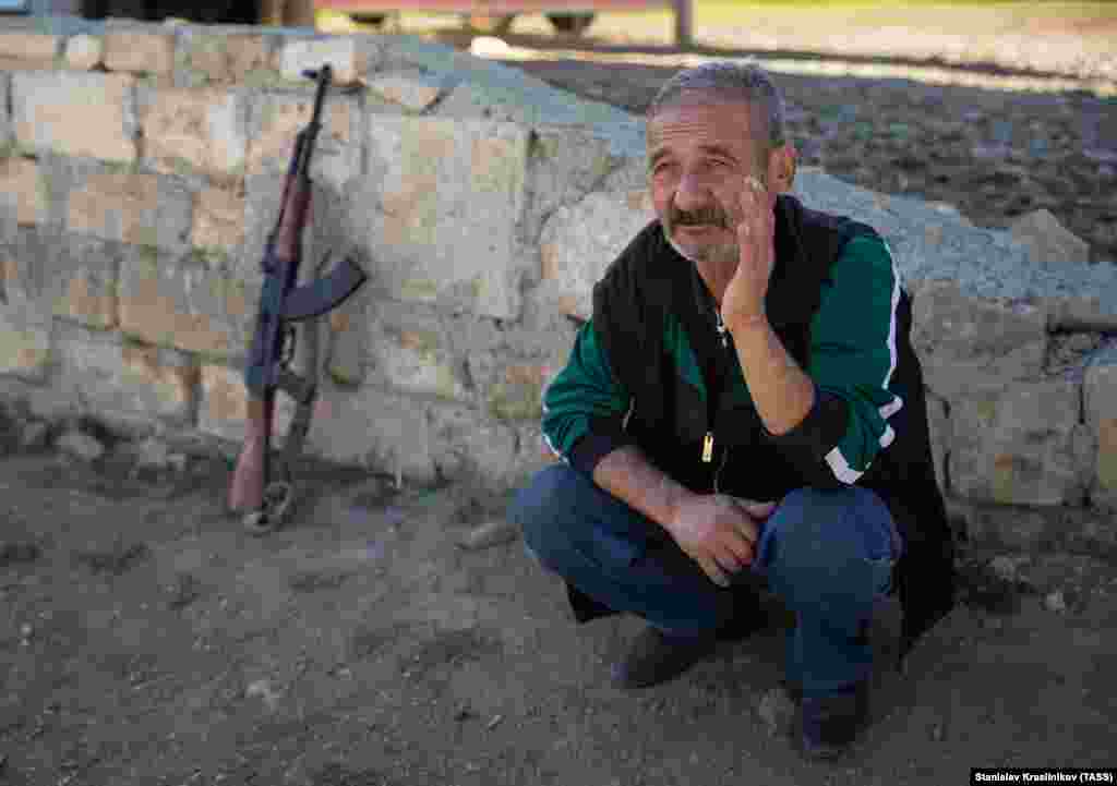 Еден постар етнички Ерменец седи покрај оружјето во Аветарнотс. Некои борци во сегашниот конфликт го расчистија старото оружје складирано во нивните домови и последно користено во војната во Нагорно Карабах, што заврши во 1994 година