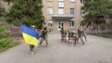 Ukrainian servicemen posing with a flag 