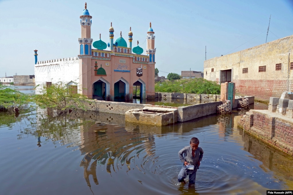 Një djalë duke kaluar nëpër ujërat e përmbytjeve në distriktin Jaffarabad në Pakistanin qendror, më 19 shtator. Sezoni i shirave monsune të vitit 2022 ka sjellë sasi tri herë më shumë sesa mesatarja e reshjeve në Pakistan, duke shkaktuar përmbytjen e një pjese të madhe të vendit.