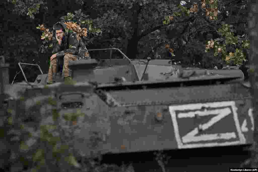 A Ukrainian soldier rests atop a Russian armored personnel carrier in Izyum on September 13.&nbsp;