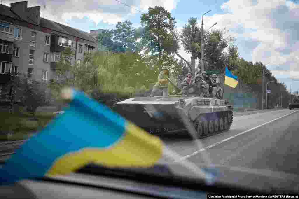 Ukrán katonák páncélozott harcjárművön haladnak át a városon