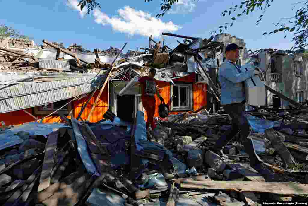 Men remove debris from a building destroyed by recent shelling in the city of Kadiyivka in the Luhansk region of Ukraine.