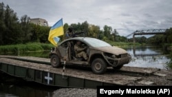 Ukrainian paratroopers cross a pontoon bridge across the Siverskiy Donets River in the recently retaken area of Izyum.