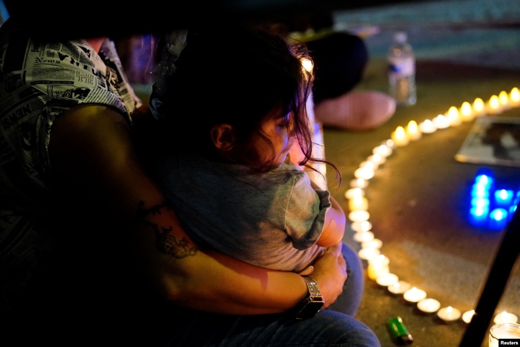 A woman cradles her daughter at a candlelit vigil protesting the death of Amini outside the Wilshire Federal Building in Los Angeles on September 22.