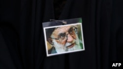 Iranski provladin demonstrant nosi sliku vrhovnog vođe ajatolaha Alija Hameneija tokom skupa protiv nedavnih antivladinih protesta u Iranu, u Teheranu, 25. septembra 2022.
