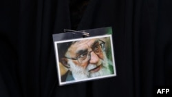یک زن طرفدار علی خامنه‌ای عکس او را بر روی چادرش سنجاق کرده است