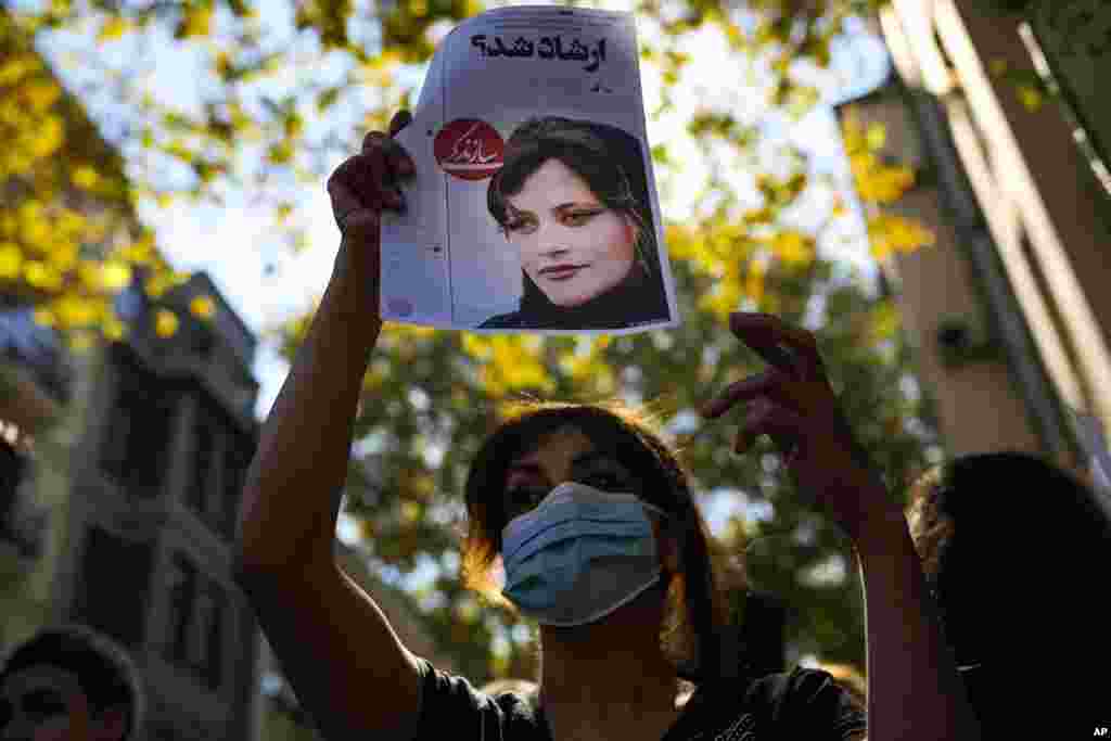 A woman raises a newspaper article reading in Persian &quot;It was Ershad?&quot; the term for Iran&#39;s morality police, during a protest outside Iran&#39;s general consulate in Istanbul.
