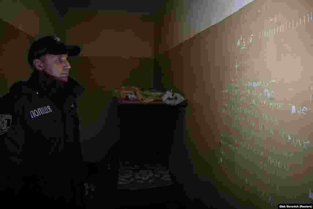 In the basement of a police station in Balaklia, used by the Russian military as a detention facility, a prayer and the number of days are chalked on the wall. Locals reported being tortured in the building.