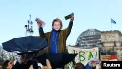 Демонстранти използват маска с лицето на председателката на Европейската комисия Урсула фон дер Лайен в Белрин. Снимката е илюстративна.