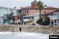 Nanosi pijeska na obali u Long Beachu u Kaliforniji tokom tropske oluje Kay, 10. septembar 2022.