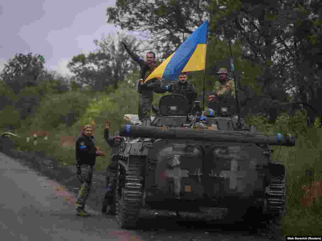 Membri ai serviciilor ucrainene stau pe un vehicul de luptă de infanterie BMP-1, pe fondul atacului Rusiei asupra Ucrainei, în apropiere de orașul Izium.&nbsp;Fotografie din 14 septembrie 2022.&nbsp;