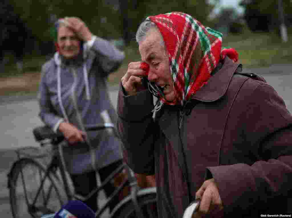Local residents react as they wait for a car distributing humanitarian aid in the village of&nbsp;Verbivka, which was also recently liberated.