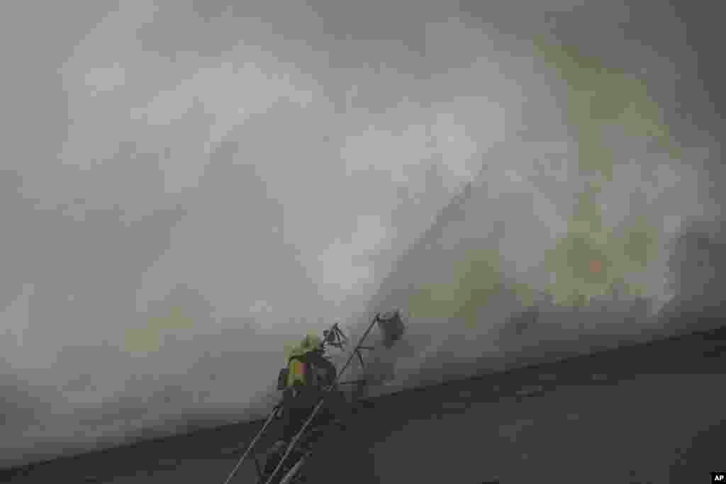 Пажарныя на месцы расейскага ракетнага ўдару ў Харкаве.