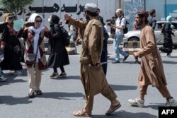 Taliban fighters disperse Afghan women protesters in Kabul on August 13.