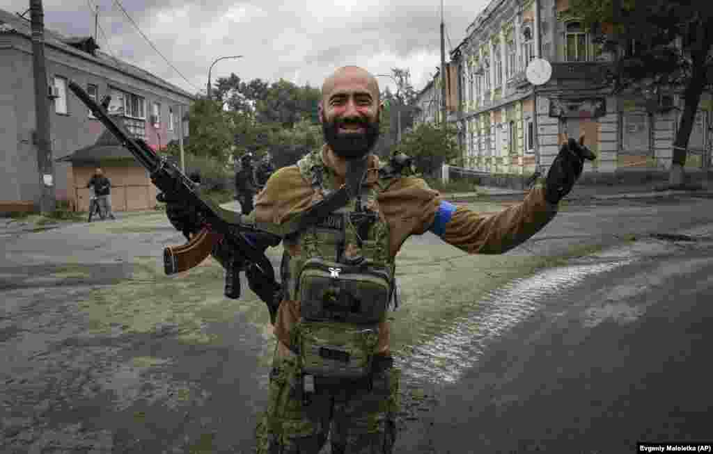 A Ukrainian paratrooper reacts after seeing his comrades in the recently retaken city of Izyum on September 14. After a lighting counteroffensive liberated swaths of territory in the eastern part of the country, Ukrainian President Volodymyr Zelenskiy traveled to Izyum where he greeted soldiers and took part in a flag-raising ceremony.