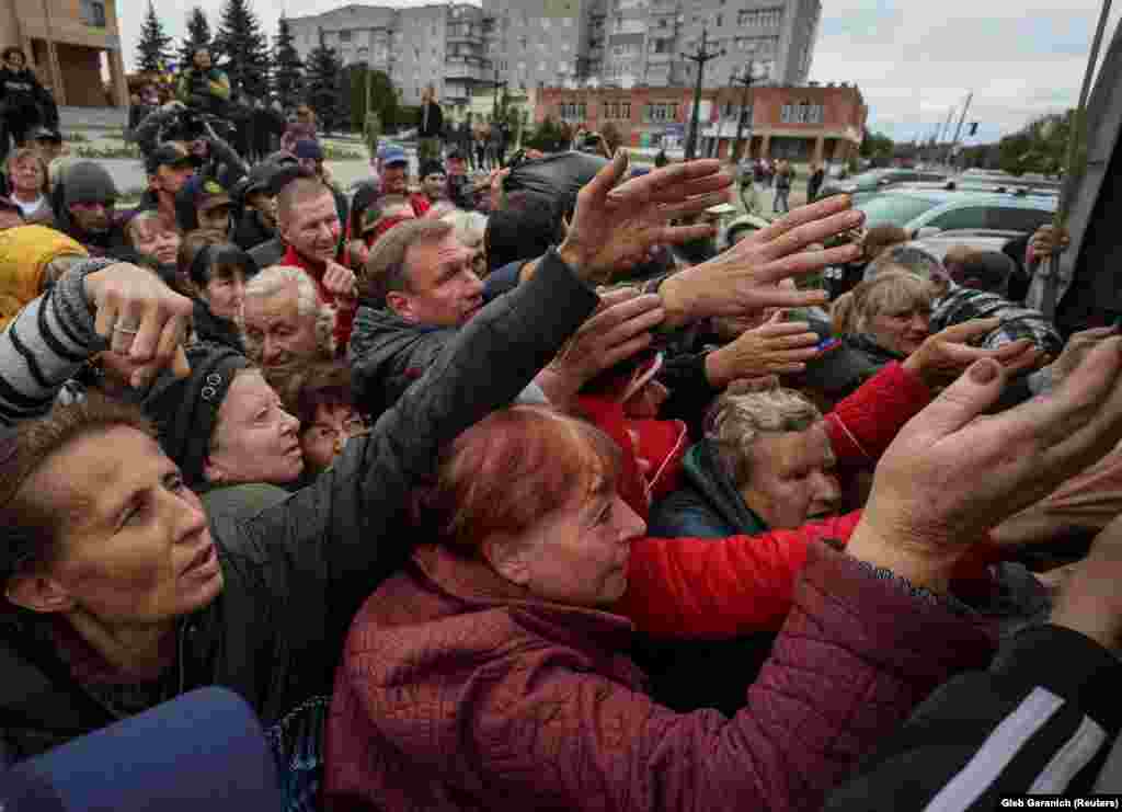 Локалните жители се собираат во близина на камион кој дистрибуира хуманитарна помош во ослободениот град Балаклија.