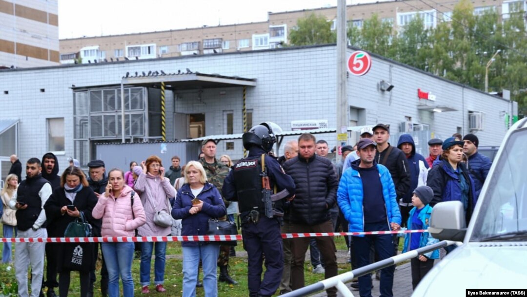 Onlookers gather near the crime scene after the shooting in Izhevsk on September 26.