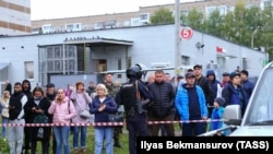 Onlookers gather near the crime scene after the shooting in Izhevsk on September 26.