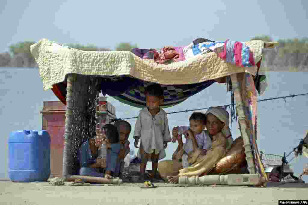 A flood-affected Pakistani woman sits with her children inside a temporary tent in a makeshift camp at Sohbatpur in the Jaffarabad district of Balochistan Province.