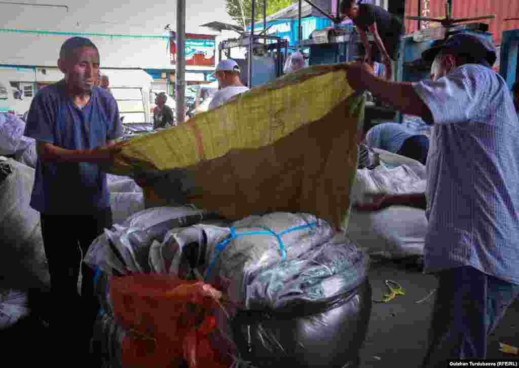 With help from a colleague, Abdullah (right) ensures that his goods are neatly packed, and more importantly, take up as little space as possible to keep shipping costs down. 