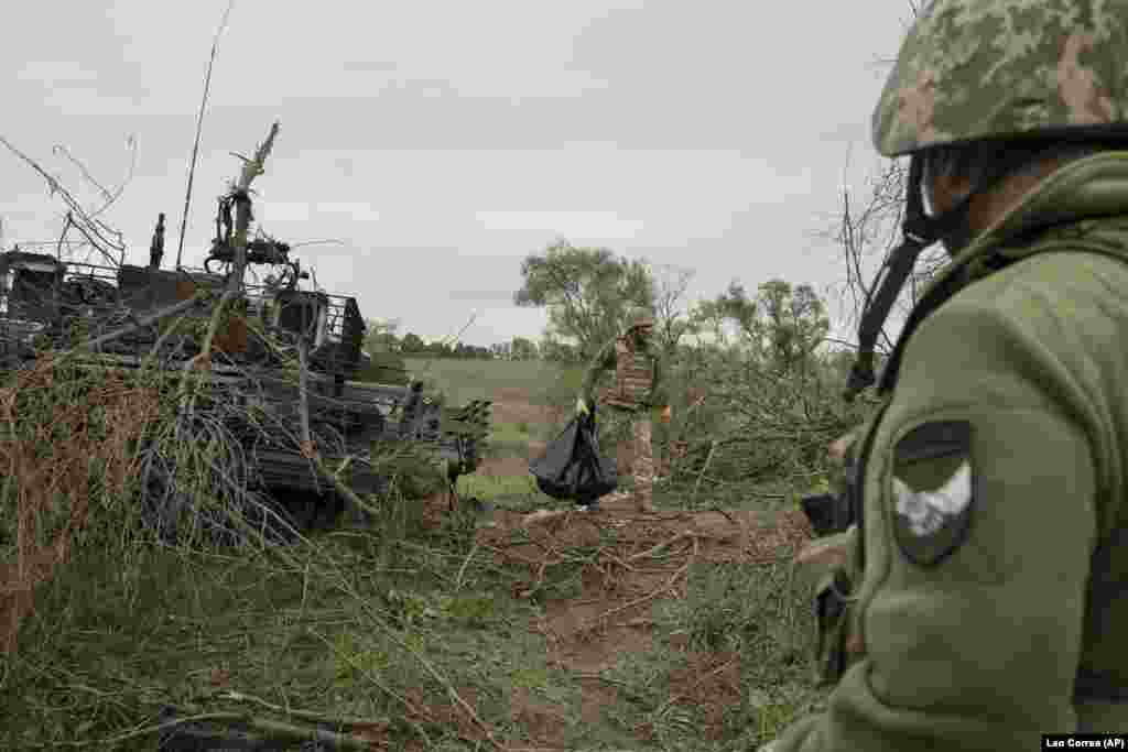 A Ukrainian serviceman holds the remains of a Russian soldier recovered from the damaged tank.&nbsp;