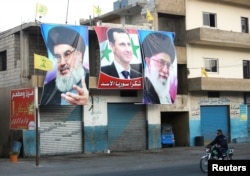 Портрети лідера «Хезболли» Саєда Гассана Насралли, сирійського президента Ассада та іранського аятолли Алі Хаменеї в ліванському селі аль-Аїн на кордоні Лівану з Сирією