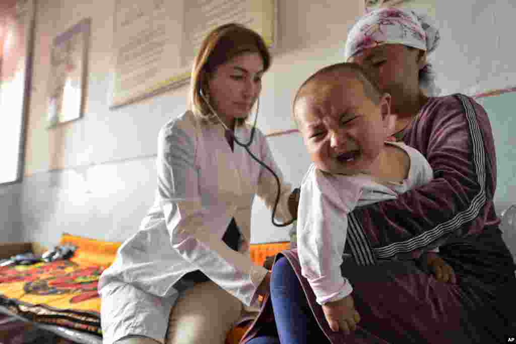 A Kyrgyz medic examines a refugee at a temporary camp on September 19 in Kyzyl-Bel village, southeast of Bishkek, where locals displaced by the border conflict with Tajikistan have fled.