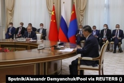 Си Цзиньпин (справа на первом плане) и Владимир Путин (слева на первом плане) на встрече на полях саммита Шанхайской организации сотрудничества в Узбекистане в сентябре
