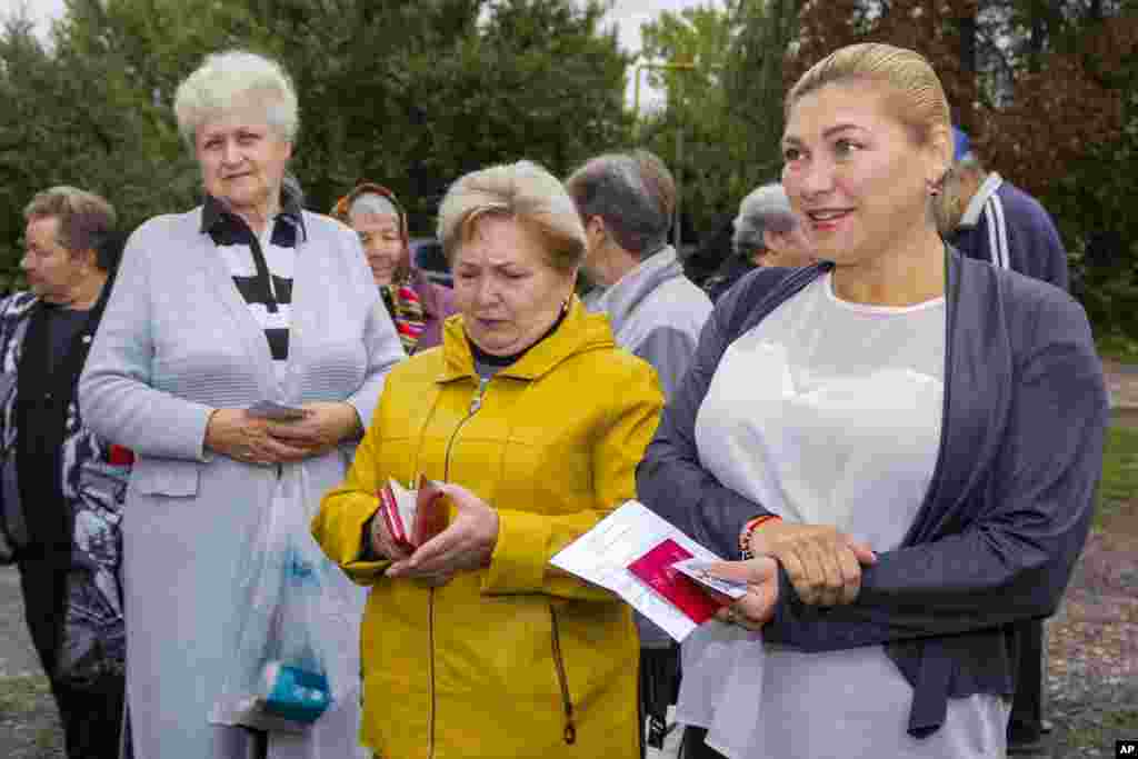 Ukrajinci se okupljaju kako bi glasali na montiranim referendumima ispred mobilnog biračkog mjesta u selu Krasni Jar nedaleko od Luganska, u istočnoj Ukrajini, 23. septembar 2022. - na fotografiji:&nbsp;Regioni Lugansk, Donjeck, Herson i Zaporožje provode od 23. do 27. septembra takozvane referendume usred najvećeg kopnenog rata u Evropi od Drugog svjetskog rata, onog koji je primorao mnoge potencijalne glasače da pobjegnu.