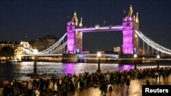 Ljudi čekaju u redu da odaju počast dok je Tower Bridge osvijetljen ljubičastom bojom u čast preminule britanske kraljice Elizabete, 16. septembra 2022. 