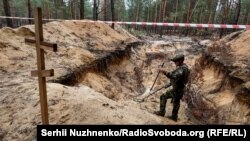 Масові поховання місцевих та солдатів ЗСУ під Ізюмом, виявлені після звільнення території від російської армії. Фото: 15 вересня 2022 року