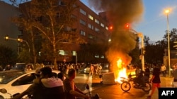 Demonstrators gather around a burning barricade during a protest for Mahsa Amini on September 19 in Tehran.