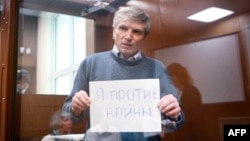 Aleksei Gorinov holds up a sign saying, "I'm against war" in court. (file photo)