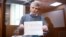 Aleksei Gorinov holds up a sign saying, "I'm against war" in court. (file photo)