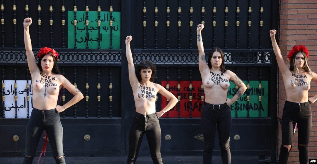 Anëtarët e grupit aktivist feminist Femen me fjalët &quot;Grua, jetë, liri&quot; të shkruara në gjoks e të zhveshura duke protestuar jashtë Ambasadës së Iranit në Madrid, më 23 shtator.