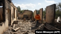 ARMENIA -- Firefighters work among the ruins of a house in the village of Sotk hit by Azerbaijani shelling during border clashes, September 14, 2022.