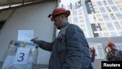 Građevinski radnik glasa tokom referenduma o priključenju samoproglašene Narodne Republike Donjeck Rusiji, 26. septembra 2022.