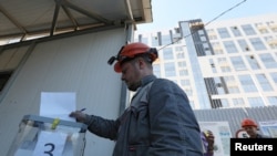 Građevinski radnik glasa tokom referenduma o pridruživanju Rusiji u Sevastopolju, na Krimu, 26. septembra 2022.