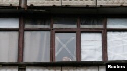 Žena na prozoru u gradu Horlivka u regiji Donjeck, jednoj od separatističkih regija na istoku Ukrajine koje podržava Rusija, mart 2022. 