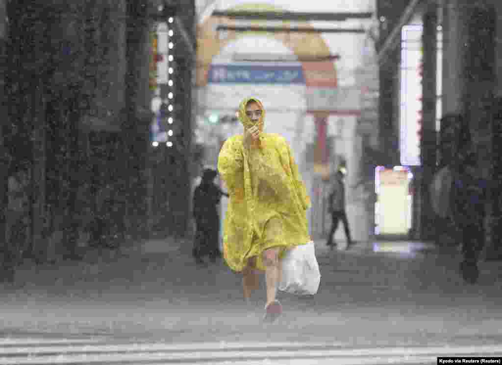Muškarac hoda ulicom po jakoj kiši i vjetru uzrokovanom tajfunom Nanmadol u Kagošimi na najjužnijem japanskom glavnom ostrvu Kjušu 18. septembra 2022.