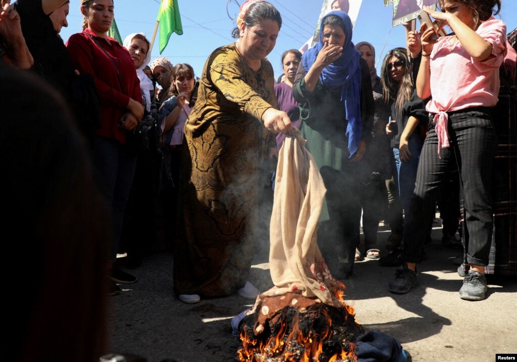 Në shenjë solidariteti me gratë iraniane, disa gra djegin shamitë gjatë një proteste në qytetin e kontrolluar nga kurdët, Qamishli në Siri.
